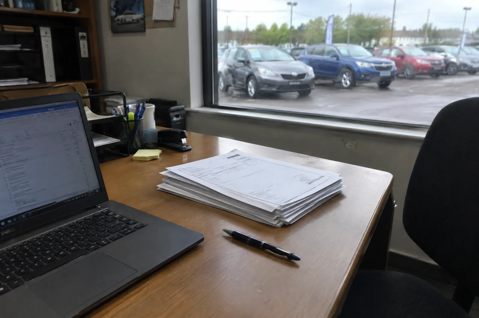 Bureau in een klein kantoor met een laptop en een nette stapel inkoopfacturen